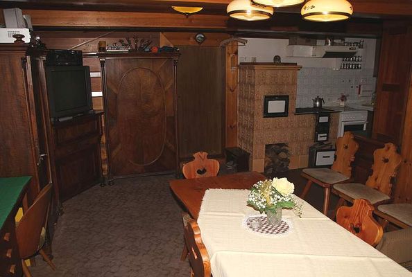 Ein Wohnzimmer mit Kachelofen in der Hütte Pultarka