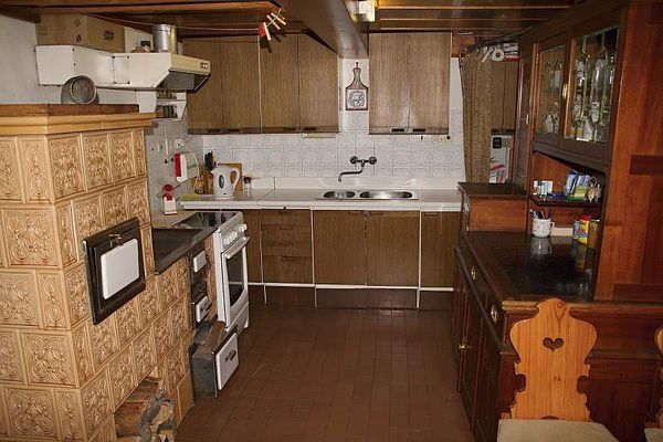 Ein Wohnzimmer mit Kachelofen in der Hütte Pultarka